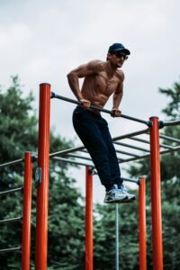 Fit man doing a workout on outdoor pull-up bars, showcasing strength and fitness.